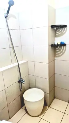 a bathroom with a toilet with a shower at Veronica Grey's Staycation 2BR in Manila