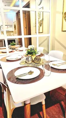 a white table with plates and silverware on it at Veronica Grey's Staycation 1BR in Manila
