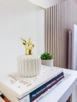 a gold deer ornament sitting on top of two books at Eastovia Suites city center condo with pool at Fame in Manila