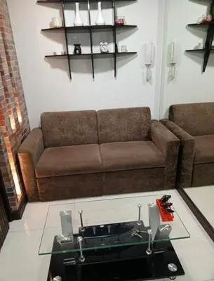 a living room with a couch and a glass table at ADB Ortigas Tower in Manila