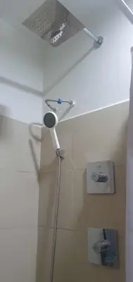 a shower with a shower head in a bathroom at StayWisePH at MOA in Manila