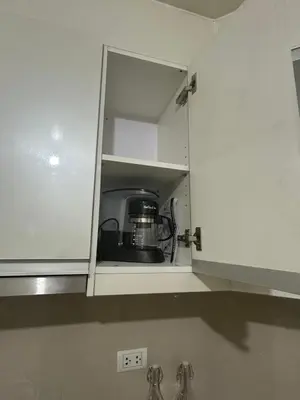 a kitchen with white cabinets and a appliance at Relaxing Pasay Retreat Pool & WiFi - Harlhy in Manila