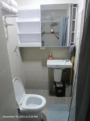 a small bathroom with a toilet and a sink at Coast Residences in Manila