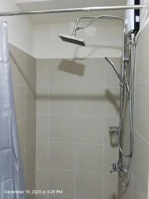 a shower with a glass door in a bathroom at Coast Residences in Manila