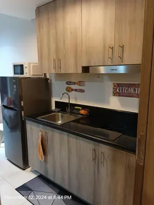 a kitchen with a sink and a refrigerator at Coast Residences in Manila