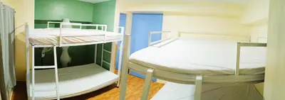two bunk beds in a room with green walls at Agate's Loft in Manila