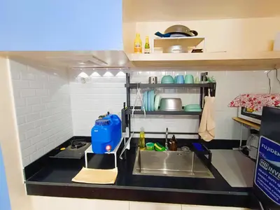a miniature kitchen with a sink and a counter at Agate's Loft in Manila