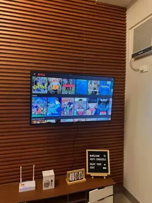 a flat screen tv hanging on a wall at Charm Residences Staycation by Ashti in Manila