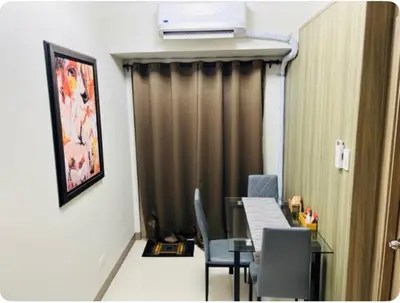 a room with a table and chairs and a curtain at Coast Residences in Manila