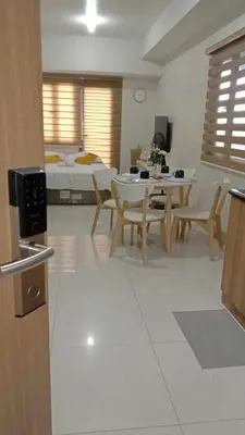 a living room with a table and chairs and a bed at Shore 3 Tower 2 near MOA Parking WI-FI Netflix in Manila