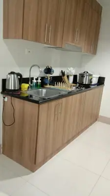 a kitchen with wooden cabinets and a sink at Shore 3 Tower 2 near MOA Parking WI-FI Netflix in Manila