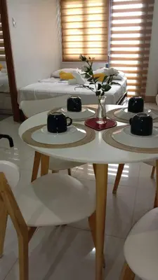 a table with two plates and a vase with flowers on it at Shore 3 Tower 2 near MOA Parking WI-FI Netflix in Manila