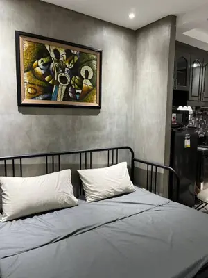 a bedroom with a bed with a painting on the wall at Compact Urban Studio-Type Unit in Manila