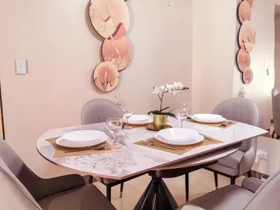 a dining room with a table with chairs and mirrors at Modern Condo in Prime Location in Manila