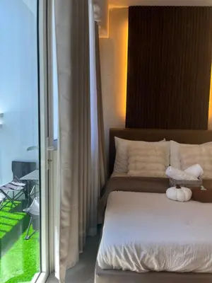 a bed with two stuffed animals on it next to a window at Hiraya Staycation in Manila