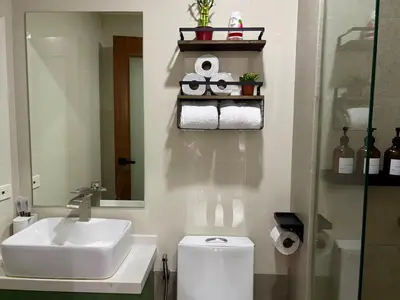 a bathroom with a sink and a toilet and a mirror at Condo in Mandaluyong with BGC Skyline in Manila