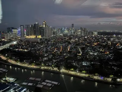 a view of a city at night with a river at Condo in Mandaluyong with BGC Skyline in Manila
