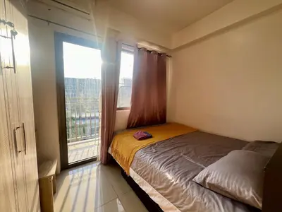 a bedroom with a bed and a large window at Shore Residences Pasay Balcony Studio Unobstructed View Near SM Mall of Asia in Manila