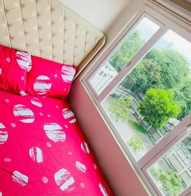 a bedroom with a red bed next to a window at Cozy condotel Field Residence in Manila