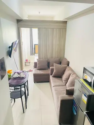 a living room with a couch and a table at Cozy condotel Field Residence in Manila