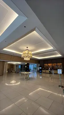 a large lobby with a table and a chandelier at Shell Residences near MOA and NAIA by Mae in Manila