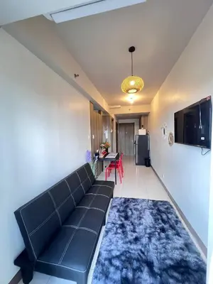 a living room with a black couch and a kitchen at UNISTAY Coast Res R19 w Bal Sunset Vw Worldtrade in Manila