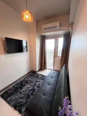 a living room with a couch and a flat screen tv at UNISTAY Coast Res R19 w Bal Sunset Vw Worldtrade in Manila