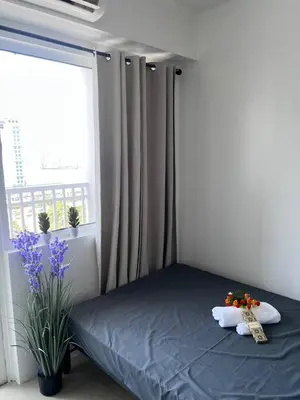 a bedroom with a bed and a window with flowers at UNISTAY Shore Res w Bal Manila Bay View nr MOA in Manila