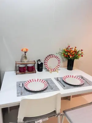a table with red and white plates on it at UNISTAY Shore 3 Pool View w Balcony near MOA in Manila