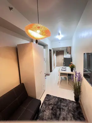 a living room with a couch and a table at UNISTAY Shore 3 Pool View w Balcony near MOA in Manila