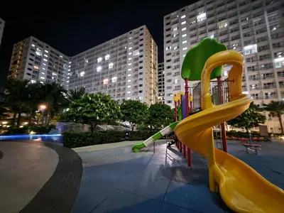 a playground with a yellow slide in a park at night at Stonewood Suite by Staycationplus with FREE PARKING in Manila