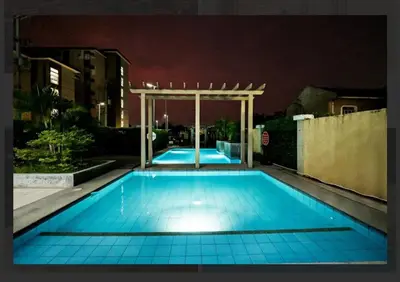 a swimming pool at night with a pergola at Coho Staycation with Free swimming in Las Pinas in Manila