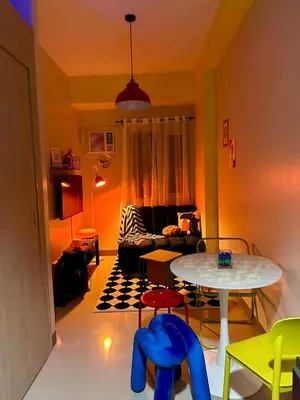 a living room with a table and a couch at RoVi,s Nook SMDC Charm in Manila