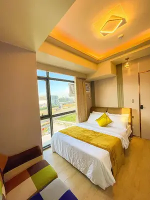 a bedroom with a bed and a large window at Lovely 1BR near Solaire, Okada I 5mins to Airport in Manila