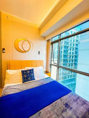 a bedroom with a bed and a large window at Lovely 2br near Airport, Solaire, & Okada - 6pax in Manila