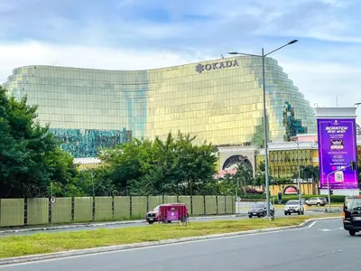 a large building with a sign on the side of a road at Lovely 2br near Airport, Solaire, & Okada - 6pax in Manila