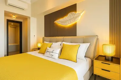 a bedroom with a bed with yellow and white pillows at Rare 3BR Modern Penthouse in BGC II Sleeps 12pax in Manila