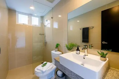 a bathroom with a sink and a toilet and a mirror at Rare 3BR Modern Penthouse in BGC II Sleeps 12pax in Manila
