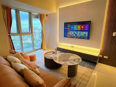 a living room with a couch and a table and a tv at Rare 3BR Modern Penthouse in BGC II Sleeps 12pax in Manila