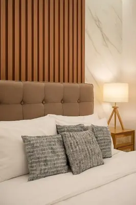 a bedroom with a white bed with three pillows at Stylish & Cozy 1 bedroom near Mall of Asia in Manila