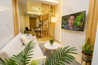a living room with a white couch and a flat screen tv at Stylish & Cozy 1 bedroom near Mall of Asia in Manila
