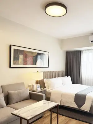 a hotel room with a bed and a couch at Savea Bay City Manila in Manila