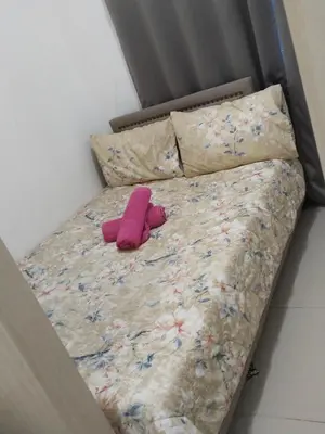 a bed with a pink stuffed animal on it at MOA Sea Residences Condotel in Manila