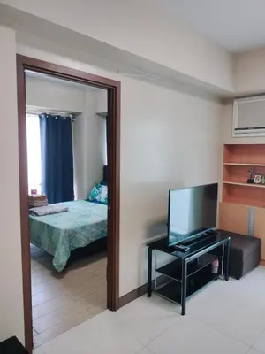 a room with a mirror and a television and a bed at Rqui Family Room Pasay City in Manila