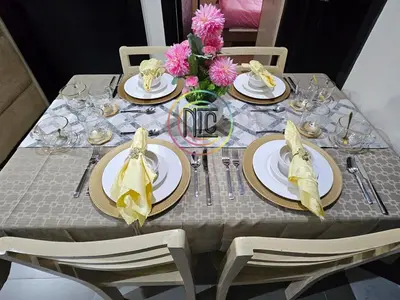 a table with plates and napkins on it at Cozy 2BR UnitN Free Pool Gym with Karaoke Netflix in Manila