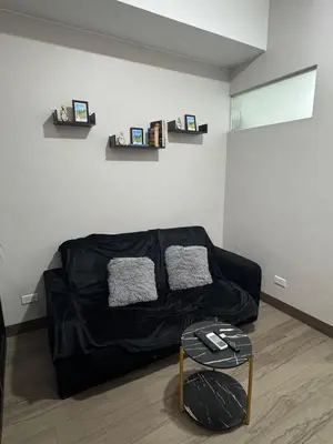 a living room with a black couch and a table at Sentinel Residences 1 bedroom partition in Manila