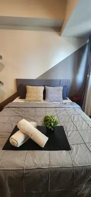 a bed with two towels and a plant on it at 11a Spacious Suite with Resort Amenities Free Parking with Washer Great for Long Stays in Manila