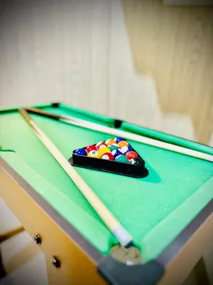 a pool table with a cue ball on it at Addison Place at SMDC Charm in Manila
