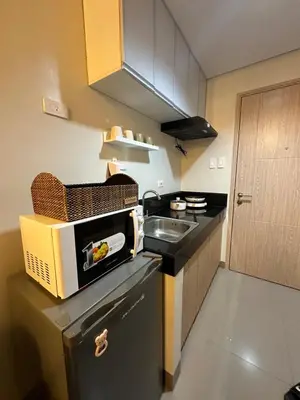 a small kitchen with a sink and a microwave at Addison Place at SMDC Charm in Manila