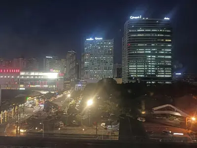 a city lit up at night with tall buildings at Deca Cubao Tower Budget Condo by Ashti in Manila